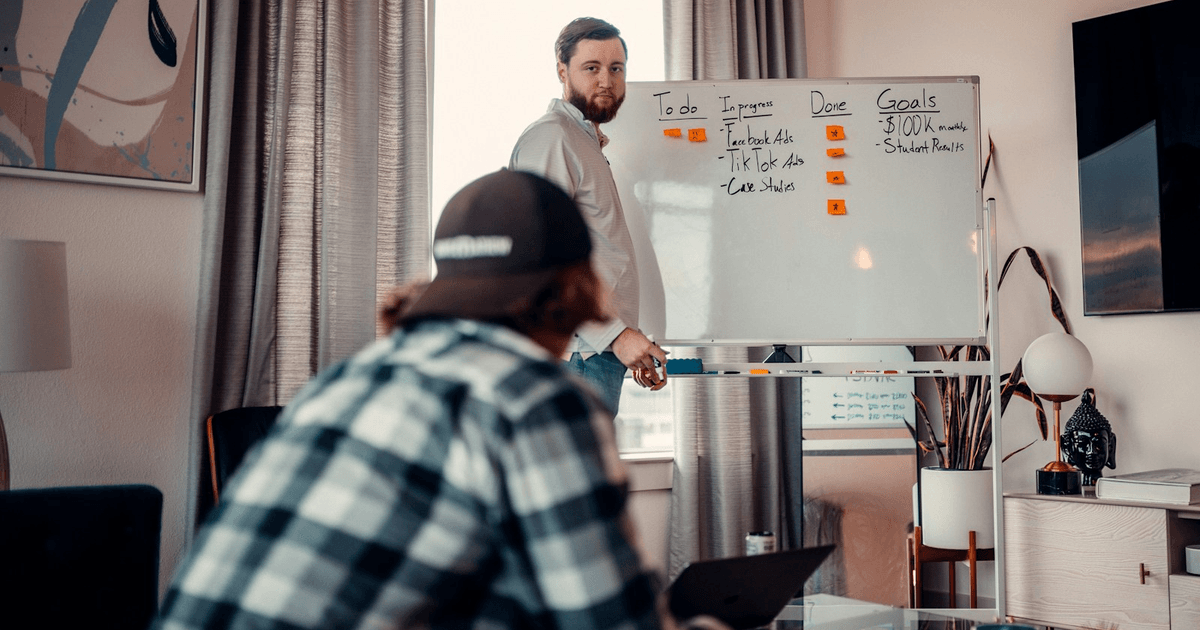 UK developer team discussing architecture on a whiteboard in a modern office