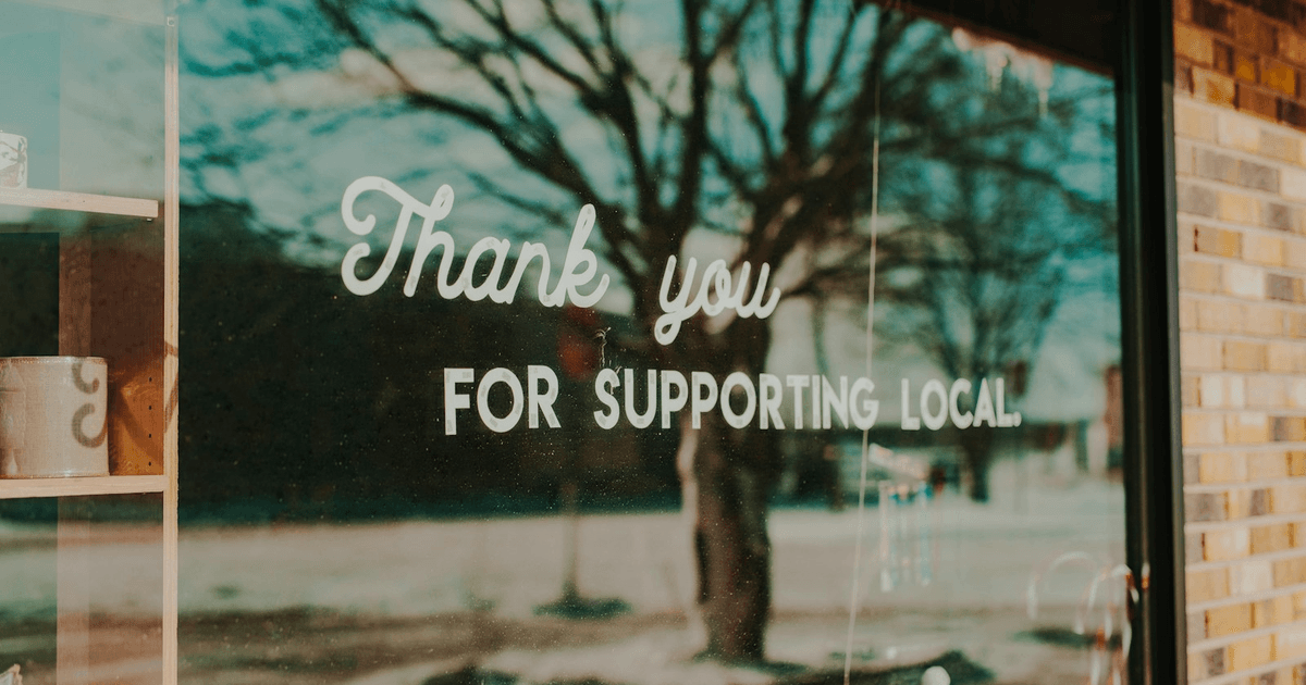 Local shop owner standing outside a high street storefront in the UK