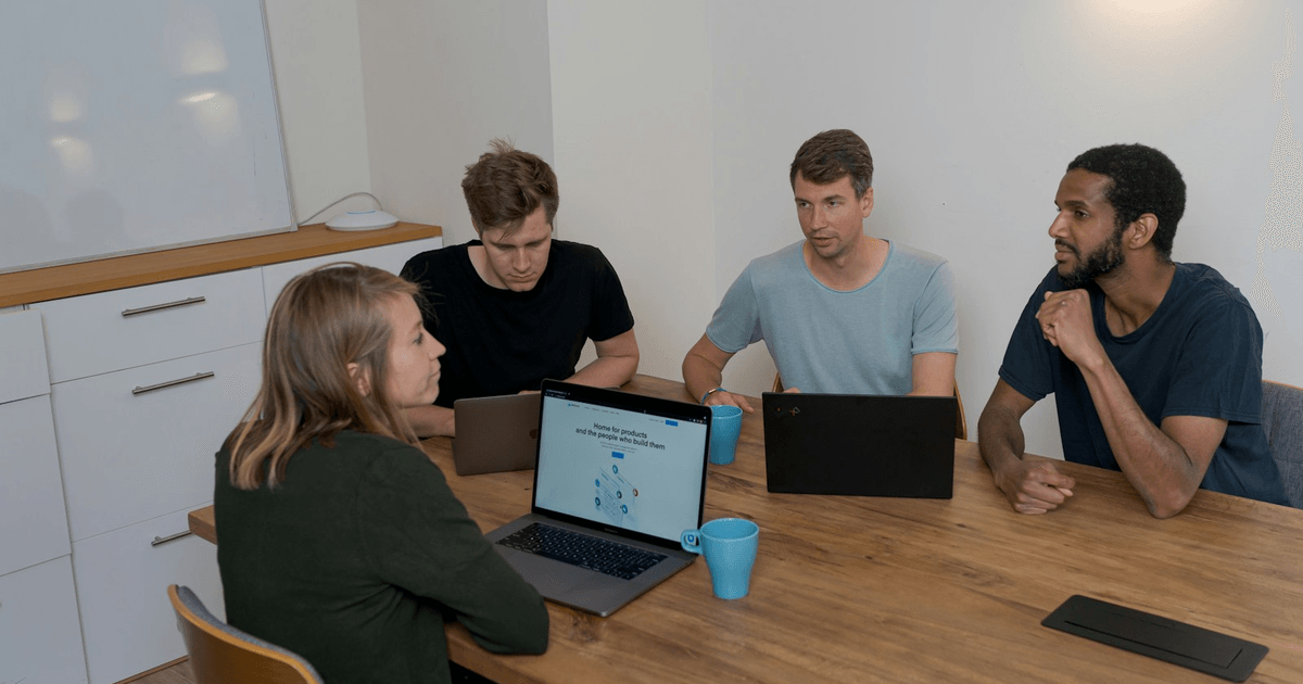 UK development team collaborating on laptops during a code review meeting